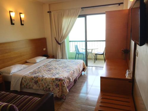 a hotel room with a bed and a balcony at Victory Byblos Hotel & Spa in Jbeil