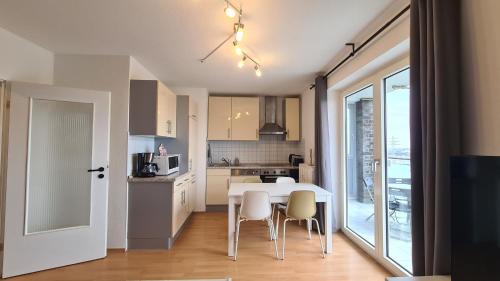 cocina y comedor con mesa y sillas en Cozy 2-Room Flat, for Vacation & Fair (Messe Düsseldorf), en Ratingen