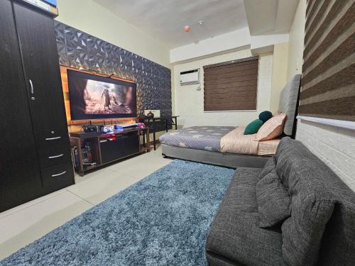 a bedroom with a couch and a large screen tv at Gamingcation in Manila