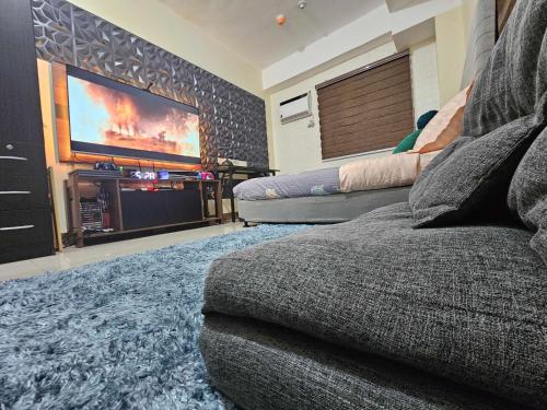 a living room with a couch and a flat screen tv at Gamingcation in Manila