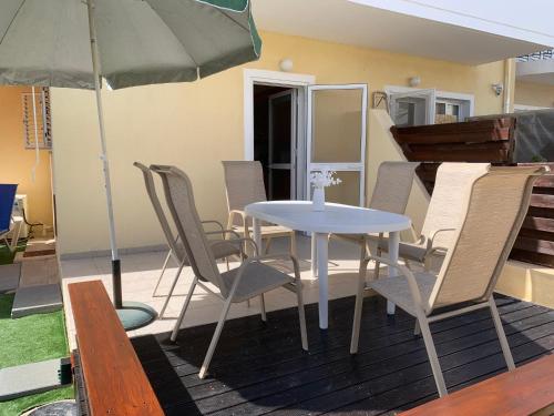 a table and chairs on a deck with an umbrella at KambiGardens in Chlorakas