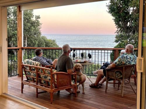 a group of people sitting on a porch with a dog at The Dunes - Couples *Beachfront* in Lake Tyers