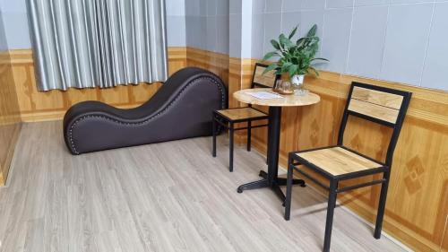 a couch and a table and chair in a room at Hương Giang Hotel & Coffee in Thái Bình