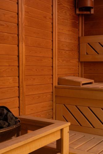 a sauna with wooden walls and a wooden bench at Hotel Golden Tulip Ana Tower Sibiu in Sibiu