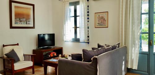 un soggiorno con divano e TV di Summer Villa Zefiros, close to Kaiki beach a Spetses