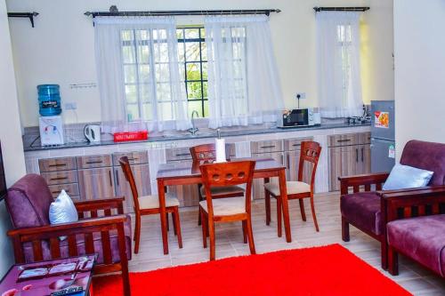 a kitchen with a table and chairs and a kitchen with a counter at Gatville Serene Gardens in Kiserian