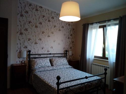 1 dormitorio con 1 cama y papel pintado con motivos florales en Villa Arianna, en Cori