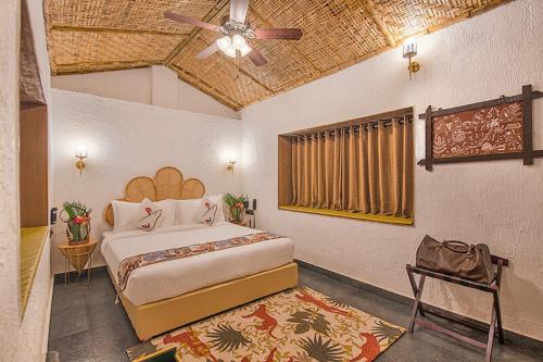 Schlafzimmer mit einem Bett und einem Deckenventilator in der Unterkunft Wild Roots Riverside Lodge in Bhandardara