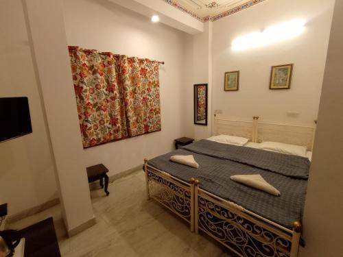 sypialnia z łóżkiem i obrazem na ścianie w obiekcie Little Peepal House w mieście Udaipur