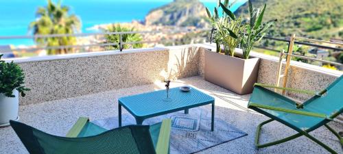 a patio with two chairs and a blue table at Al 33 Giri in Cefalù