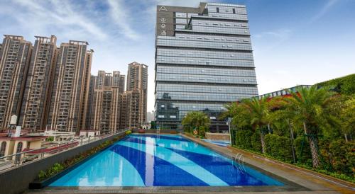a swimming pool in a city with a tall building at Atour Hotel Foshan Nanhai Qiandeng Lake Guicheng in Nanhai