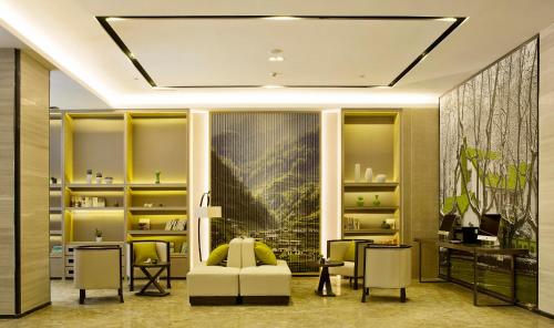 a living room with a white couch and chairs at Atour Hotel Presidential Residence Nanjing in Nanjing