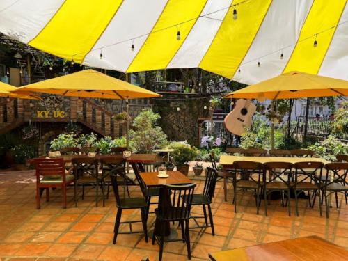 a restaurant with tables and chairs with yellow umbrellas at Memory Villa in Da Lat
