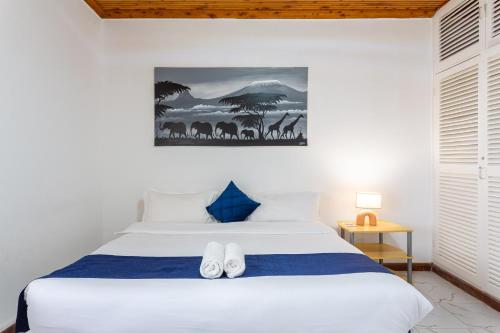a bedroom with a bed with white shoes on it at Bonsai Village in Nairobi