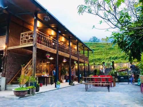 um edifício com uma mesa e bancos à sua frente em Fan Lap Homestay em Sapa