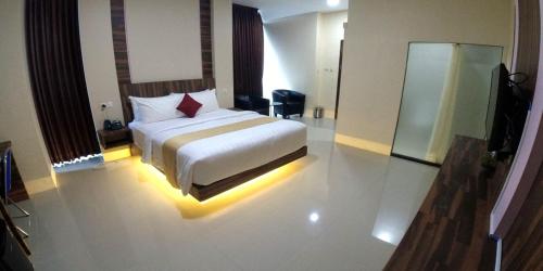 a bedroom with a bed with a light on the floor at Great Cokro Edotel Lampung in Lampung