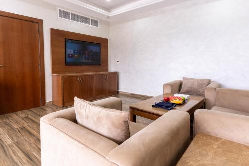 a living room with two couches and a tv at Palma Beach Resort & Spa in Umm Al Quwain