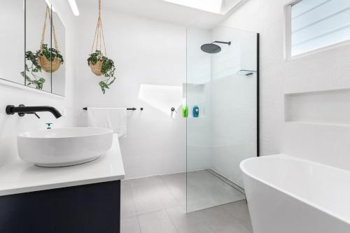 a white bathroom with a sink and a shower at Pure Elegance in Cooks Hill in Newcastle