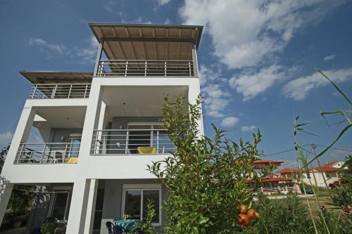 a white building with a roof on top of it at See to Sea Apartments 2 in Paralia Dionysiou