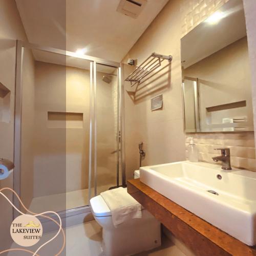 a bathroom with a sink and a shower and a toilet at The Lakeview Suites in Tagaytay