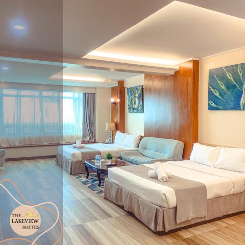 a hotel room with two beds and a couch at The Lakeview Suites in Tagaytay