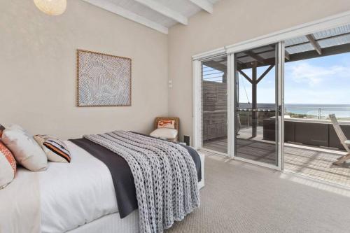 ein Schlafzimmer mit Bett und Blick auf das Meer in der Unterkunft BELLE VUE BEACH HOUSE in Binalong Bay