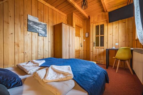 um quarto com uma cama num chalé de madeira em Pokoje gościnne Siodemka em Zakopane