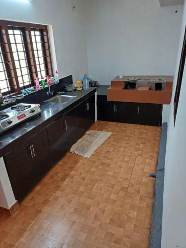 een keuken met een houten vloer en een aanrecht bij River Valley in Mananthavady