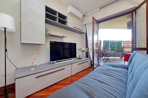 a living room with a blue couch and a flat screen tv at Copenaghen House in Fiumicino