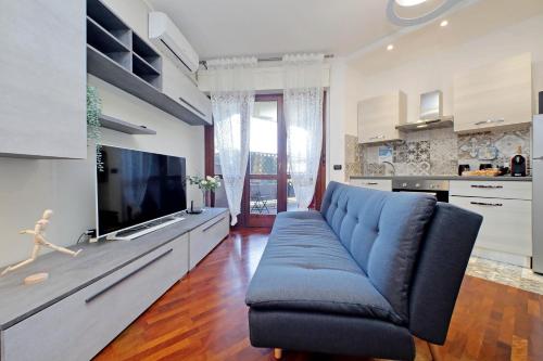 a living room with a blue couch and a tv at Copenaghen House in Fiumicino