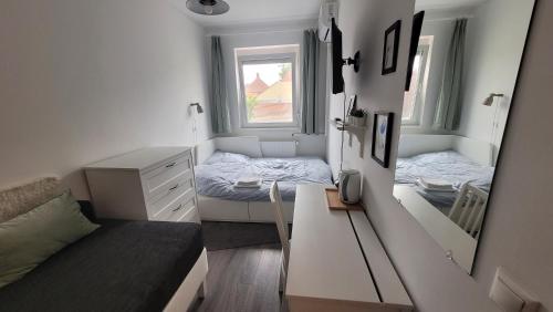a small bedroom with a bed and a mirror at Tulip Home Guest House in Vác