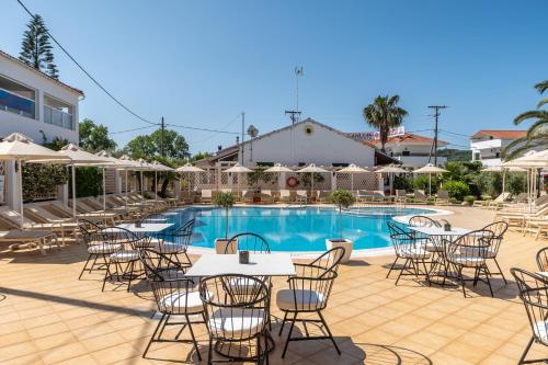 a hotel patio with tables and chairs and a pool at Metaxa Apartments in Kavos