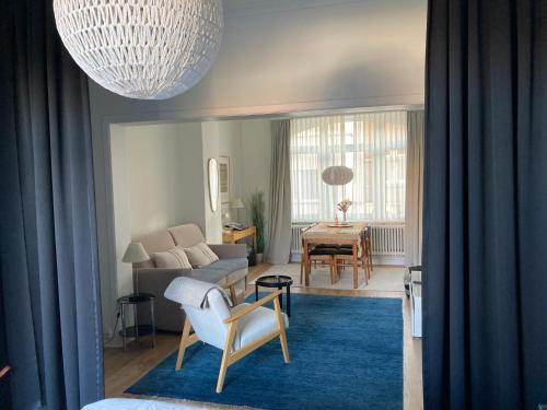 uma sala de estar com um sofá e uma mesa em Authentieke loft herenhuis em Oostende