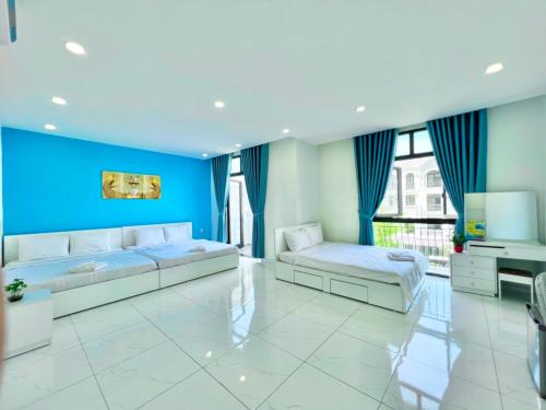 1 dormitorio con 2 camas y pared azul en Ngân Hà GrandWorld Phú Quốc, en Phu Quoc