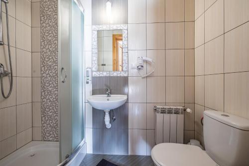 a white bathroom with a sink and a toilet at Pokoje gościnne Siodemka in Zakopane
