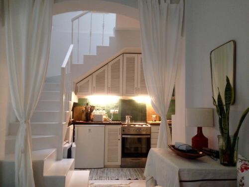 a kitchen with a staircase with white drapes at casabonita in Asilah