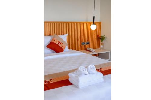 um quarto com uma cama com toalhas em LA PINO HOTEL em Songkhla