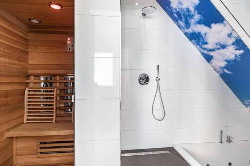 a bathroom with a shower and a bath tub at Hello Noordwijk - Wellness Huis Schoolstraat 47B in Noordwijk