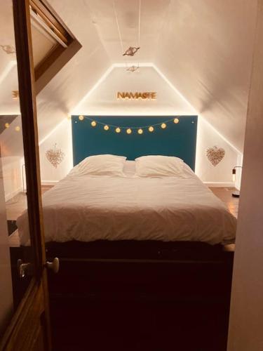 - un lit avec une tête de lit bleue dans l'établissement Guest House proche Disneyland Paris Piscine ouverte en saison estivale, à Dampmart