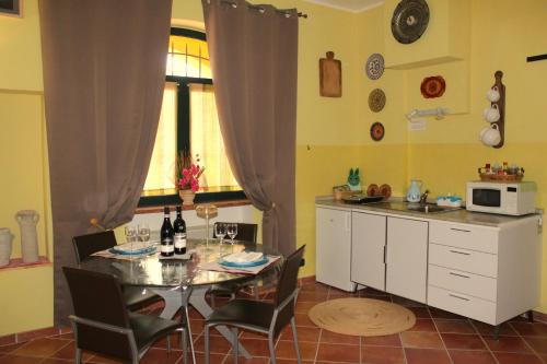 een keuken met een tafel met stoelen en een magnetron bij Mari's House by Alterego in Castagnito