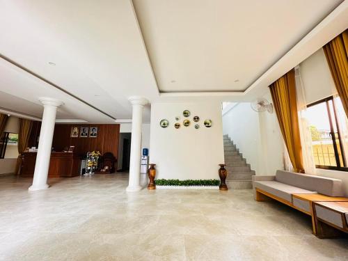 a lobby with columns and a couch and stairs at Laluna Guesthouse in Siem Reap