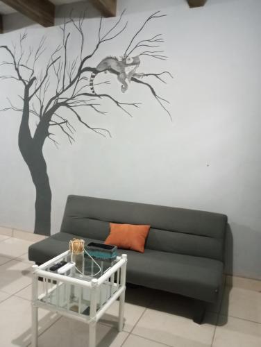 sala de estar con sofá y mural en el árbol en Renees Depas, en Álamos