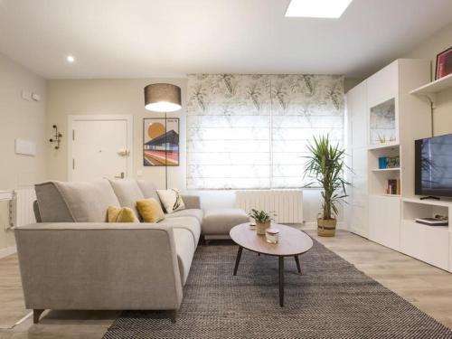 ein Wohnzimmer mit einem Sofa und einem Tisch in der Unterkunft Bilbao Costa III by Aston Rentals in Getxo