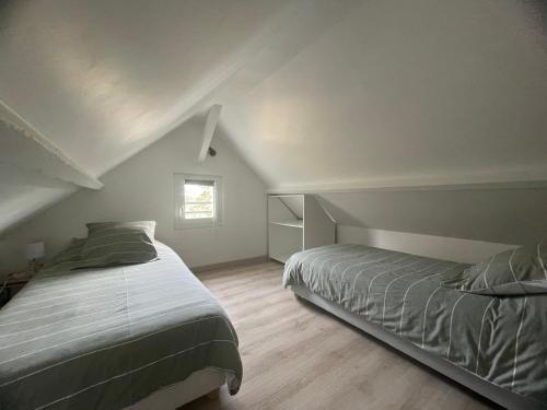 a attic bedroom with two beds and a window at Cosy Giverny in Giverny