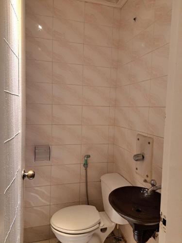 a small bathroom with a toilet and a sink at Orange Mangrove Pension House by SMS Hospitality in Puerto Princesa City