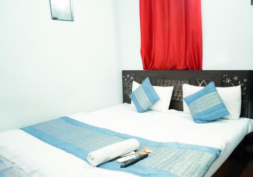 1 dormitorio con 1 cama con almohadas azules y blancas en Prince Reseidency Near Hari Nagar en Nueva Delhi