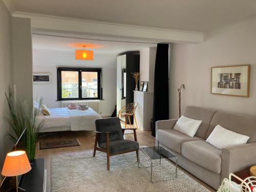 un soggiorno con divano e letto di Authentieke loft herenhuis a Ostenda