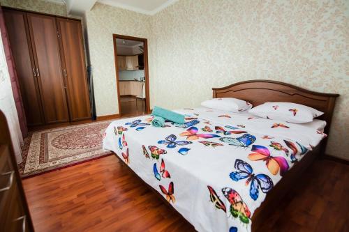 een slaapkamer met een bed met vlinders erop bij Центр города Байтерек in Astana