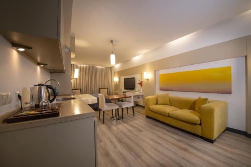 sala de estar con sofá amarillo y mesa en MY Hotel, en Izmir