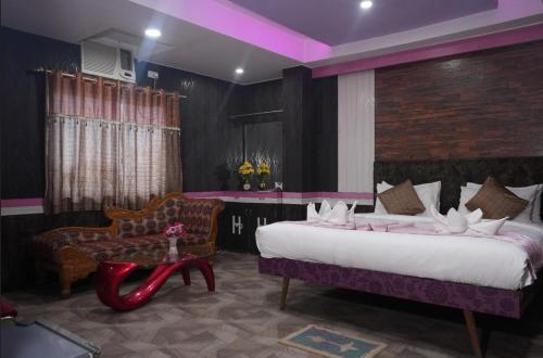 ein Schlafzimmer mit einem großen Bett und einem Stuhl in der Unterkunft HOTEL MAHAMAYA PALACE in Deoghar